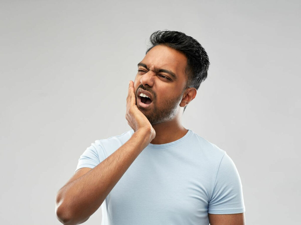 man holding his jaw suffering from tmj pain